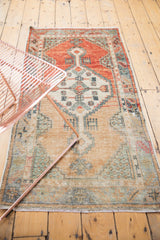 Distressed Oushak runner with abrashed field and faded floral motifs.