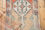Vintage distressed Oushak rug's lower field with faded blue geometric patterns and abrash.