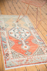 Vintage distressed Oushak runner showcasing primitive floral border in blush rose and seafoam.