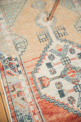 Abrashed dusty rose main border of the distressed Oushak runner with primitive floral details.
