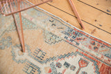 Distressed Oushak rug border with primitive floral motifs and soft hues.