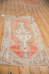Distressed Oushak runner in faded cherry red, seafoam green, and ivory tones.