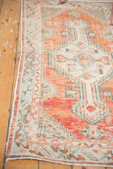 Distressed Oushak runner corner displaying primitive floral border and faded cherry red tones.