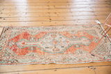 Abrashed distressed vintage Oushak runner showcasing faded cherry red, sea foam green, ivory tones.