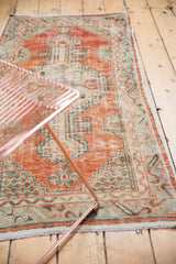 Distressed vintage Oushak runner showcasing faded cherry red and sea foam green geometric patterns.