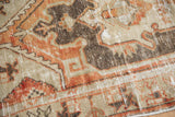 Textural detail of distressed Oushak rug, terracotta, sand, and brown geometric pattern with visible knot heads.