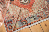 Distressed cherry red Oushak rug border, with slate blue primitive motifs and fringe.