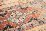 Distressed Oushak rug runner corner, featuring cross-hatched spandrel and abrashed main border.