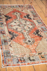Distressed Oushak runner's textured cherry red field and abrashed primitive blue border.