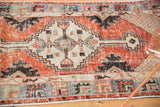 Abrashed cherry red border and ivory lattice spandrel on distressed Oushak rug corner.
