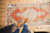 Distressed vintage Oushak runner with abrash, featuring cherry red, ivory, and seafoam green tones.