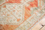 Distressed Oushak runner showing abrashed orange, ivory, and seafoam green floral buds.