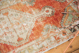 Abrashed texture and primitive floral border in tangerine, seafoam, and ivory on vintage Oushak rug.