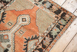 Distressed Oushak runner's corner, primitive border, and cross-hatched silver spandrel.