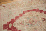 Distressed red stepped border, ivory field, and faded blush and blue floral motifs.