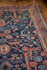Lilihan rug's deep navy blue low pile field with raspberry and sky blue floral motifs.