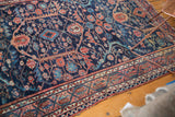 Vintage Lilihan rug border showing traditional motifs, short pile, and navy, blush, and red tones.