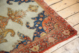 Antique Malayer rug corner, showing detailed red-orange border and blue, ivory field motifs.