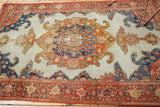 Antique Malayer rug corner with intricate red border and curvilinear blue, orange, ivory field motifs.