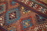 Antique Caucasian Kazak rug section showing geometric motifs in madder red, teal, and etched brown tones.