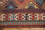 Antique Kazak rug's lower section with intricate geometric borders, colorful motifs, and original selvage.