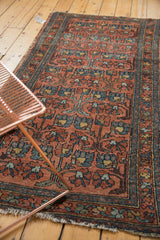 Repeating dusty blush and blue floral motif on a vintage Mehrivan rug with tattered fringe.