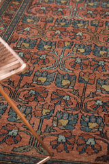 Persian Mehrivan rug's repeating floral motif with dusty blush, blue tones and even pile wear.