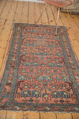 Repeating floral cross-section motif in dusty blush and sky blue, showing worn pile and tattered ends.