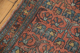 Worn dusty blush field and blue border with floral cross-section motifs on vintage Mehrivan rug.