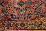 Vintage Malayer rug detail: low pile showing blush rose field, navy motifs, and geometric border.
