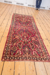 Floral patterns on the raspberry red field with the Sarouk rug's detailed side border.