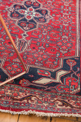 Vintage Bijar rug's white fringe, ivory border, and cherry red geometric field.