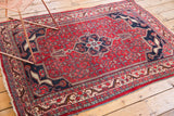 Decorative elongated ram's horn finials on the navy medallion of this Bijar rug.