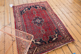 Vintage hand knotted Bijar rug corner, cherry red field, navy design, ivory border, and fringe.