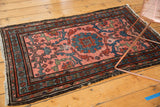 Vintage Mehrivan rug corner with blush field, scrolling tendrils, floral border, and slight tatter.
