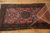 Mehrivan rug's blush field, blue tendrils, red motifs, dark border, and light tattered fringe.