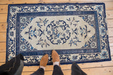 Antique Peking rug with roundel suggestive center medallion and allover ivory and cobalt blue motifs.