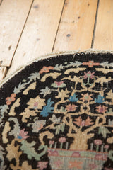 Curved edge of vintage Art Deco round rug with light tatter, beige, blue, blush plant motif.