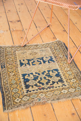 Antique Caucasian rug's left geometric flower and vine borders, navy, gold, ivory field.