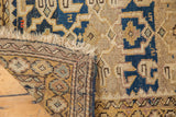 Hand-knotted reverse, fringed edge of antique Caucasian rug with navy and gold patterns.