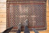 Detailed view of the Shirvan rug's dark navy lattice and unusual pawn design borders.