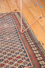 Corner of antique Shirvan rug showing unusual pawn design border, lattice field, cherry red, and dark navy.