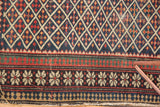 Antique Shirvan rug showcasing geometric lattice field and pawn motif borders in navy, red, green, ivory.
