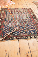 Antique Shirvan rug corner with reciprocating pawn design borders in navy, red, ivory, and fringe.