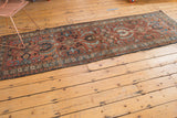 Vintage Heriz runner showing intricate border and palmette patterns in maroon and blue.