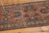 Vintage Heriz rug's prominent palmette motifs in maroon, navy, sky blue, and bronze tones.