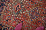 Hooked geometric medallion detail on vintage Karaja rug, cherry red and navy blue.