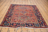 Vintage Karaja rug's bottom right corner, showing navy blue border with rectilinear floral motifs.