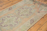 Distressed Oushak runner with faded peach, ivory, and mint green border panels.