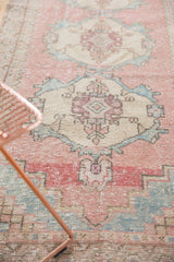 Distressed vintage Oushak rug: blush pink and powder blue medallion with even worn texture.